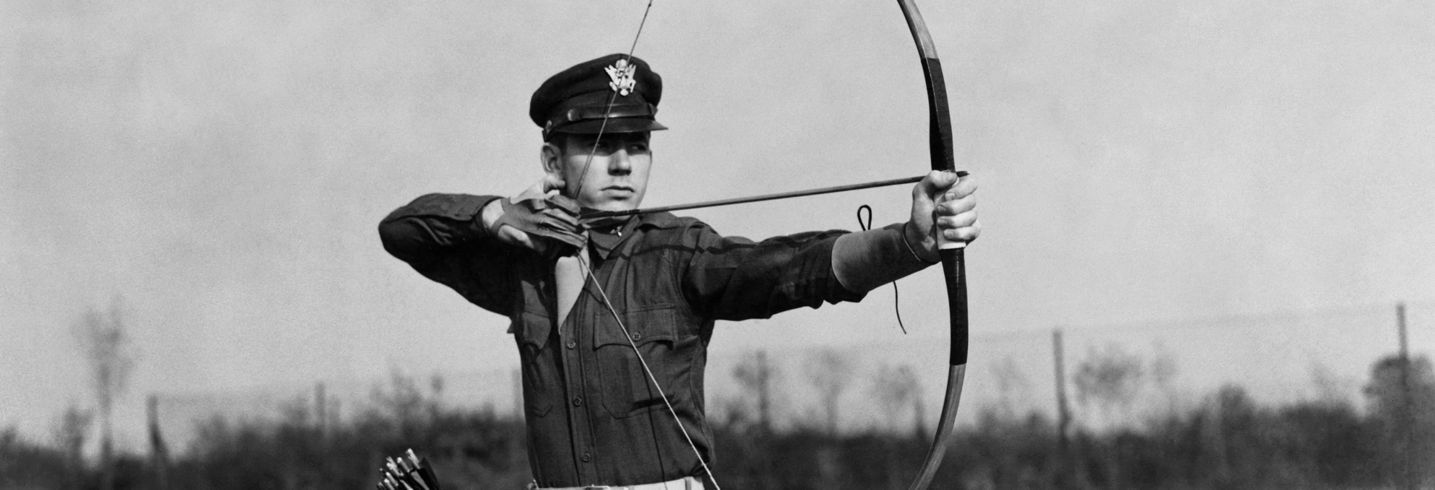 Capt Edwin Caudill of the 4th Fighter Group, the Station Adjuntant practises with his bow and arrow with which he has shot several rabbits and partridges