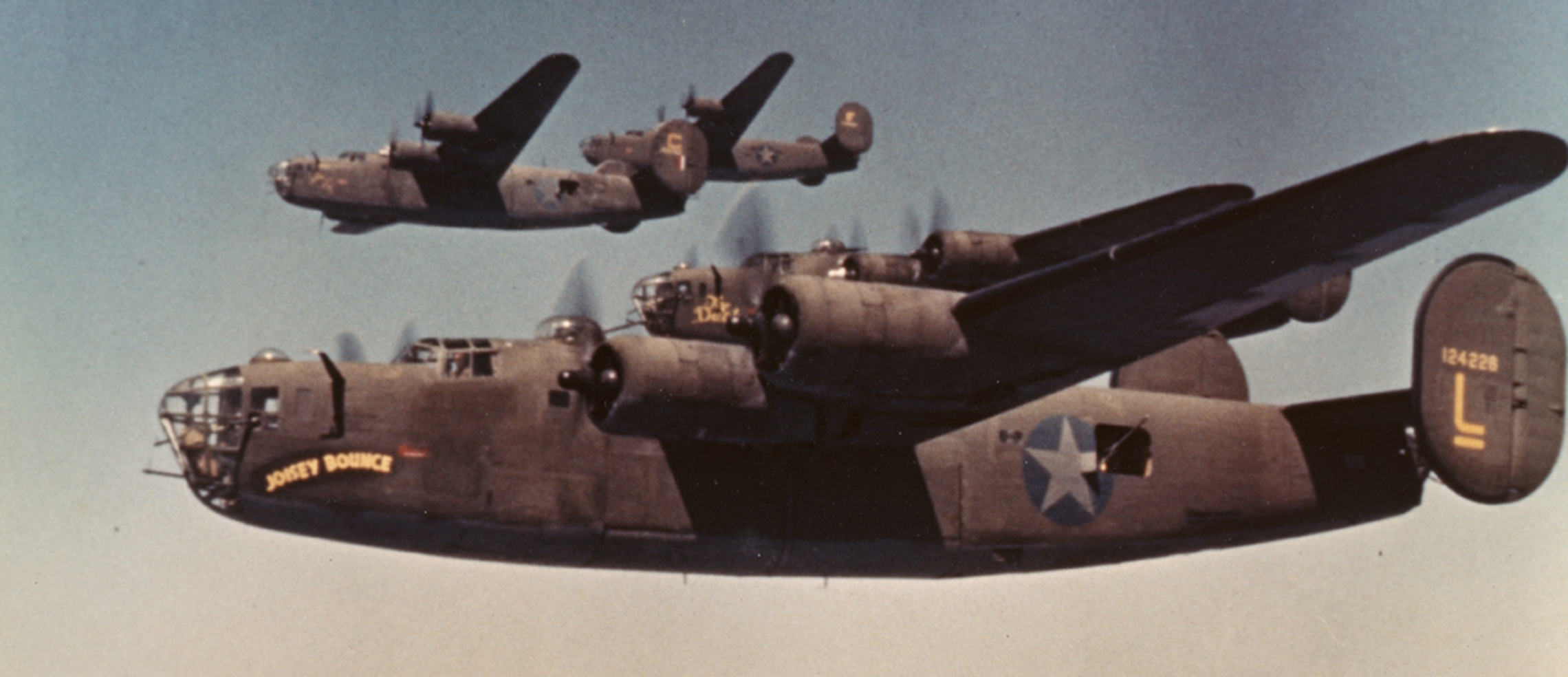 B-24 Liberators, including (serial number 41-24226 ) nicknamed "Joisey Bounce" of the 93rd Bomb Group fly in formation during a mission.