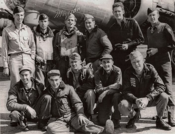 Eleven men in Air Force uniform posed in two rows in front of a military airplane.  Six men standing to the rear and five men kneeling in front.  The name "Marion" is painted on the side of the plane.