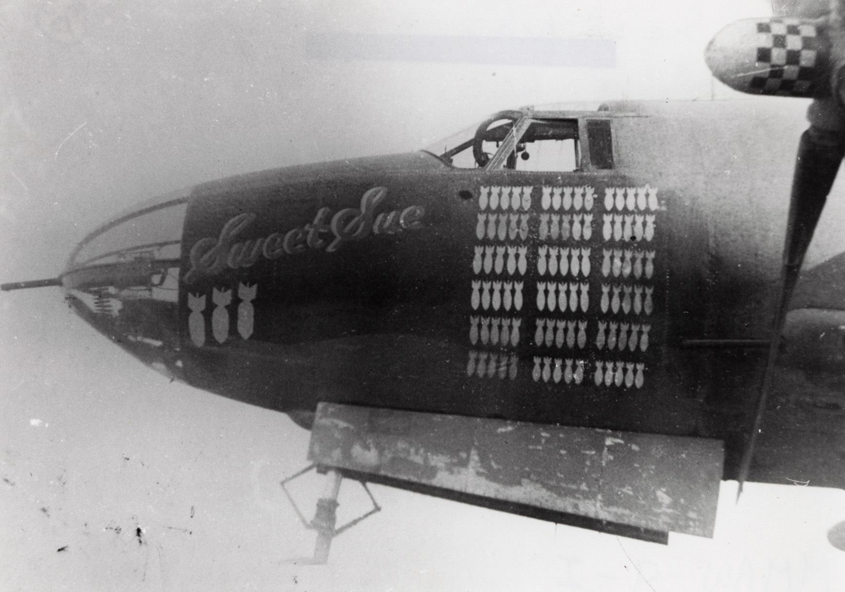 The nose art of a B-26 Marauder (serial number 41-18201) nicknamed "Sweet Sue" of the 17th Bomb Group, 12th Air Force. 
Handwritten caption on reverse: '"Sweet Sue" before 95th Mission (94th Bomb not yet painted on).'