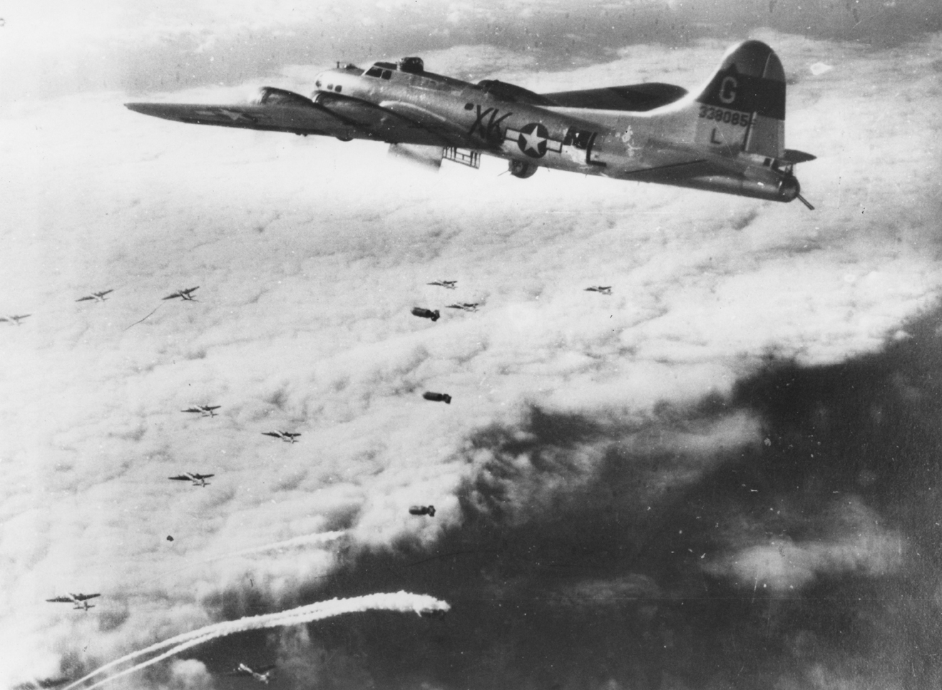 A B-17 Flying Fortress (XK-L, serial number 43-38085) nicknamed "Towering Titan" of the 305th Bomb Group drops her bombs over the target. Image via J Collins. Handwritten caption on reverse: 'Towering Titan.'