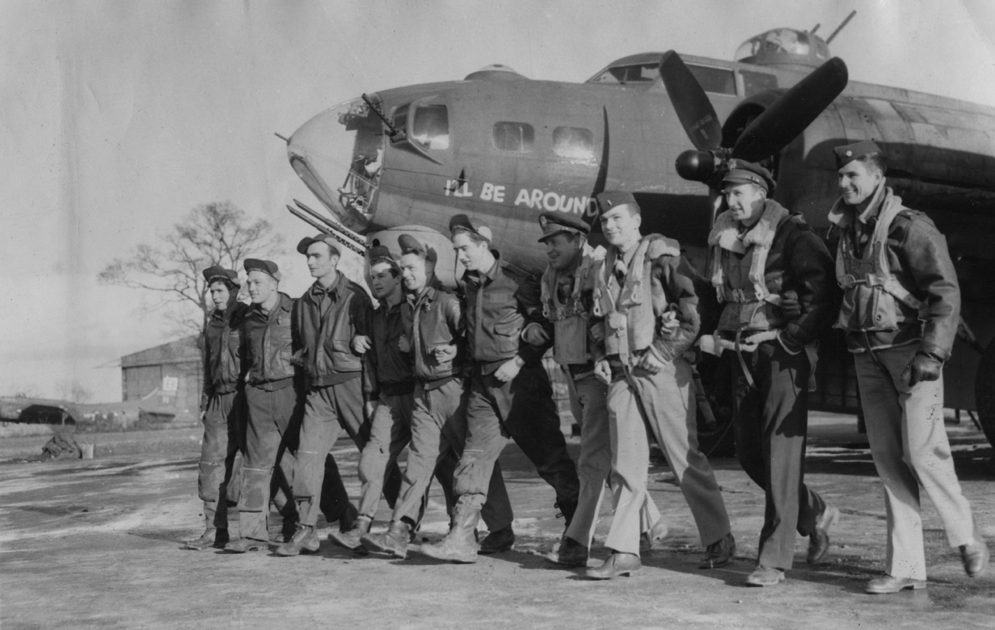 A bomber crew of the 95th Bomb Group return to Horham following a raid in their B-17 Flying Fortress (serial number 42-31320) nicknamed "I'll Be Around". Image stamped on reverse: 'Associated Press.' [stamp], '809571 [Censor no], 'Passed for publication 5 Mar 1944' [stamp] and 'USA(BRI)CCC' [ written annotation]. Printed caption on reverse: 'WRITE NEW CHAPTER IN BERLIN DIARY, FORTRESSES RAID GERMAN CAPITAL FOR FIRST TIME. Flying Fortresses battling their way through snow and a temperature of nearly "60 be