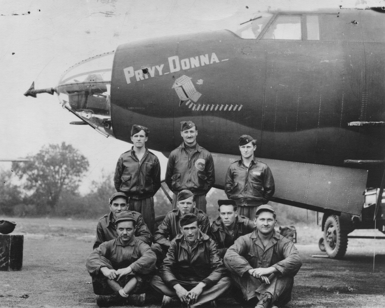 A bomber crew of the 386th Bomb Group with their B-26 Marauder (RU-A, serial number 41-31658) nicknamed "Privy Donna". A veteran has handwritten on the reverse: ''Boxted Airdrome, Colchester, Essex, England. August/Sept 1943. Rear row: Left- Co Pilot Robt. L Stevenson, 1st Lt (deceased). Centre- Flight Ldr & Pilot, Capt AL Cane. Right- Navigator, 1st Lt Jos D Watzlavick. Middle Row: Left- Radio Gunner S/Sgt Jos Hough. Centre- Flt Engr/ Gunner "Tex" DE Coffman, T/Sgt. Right: Tail Gunner S/Sgt Cliff Bates. 