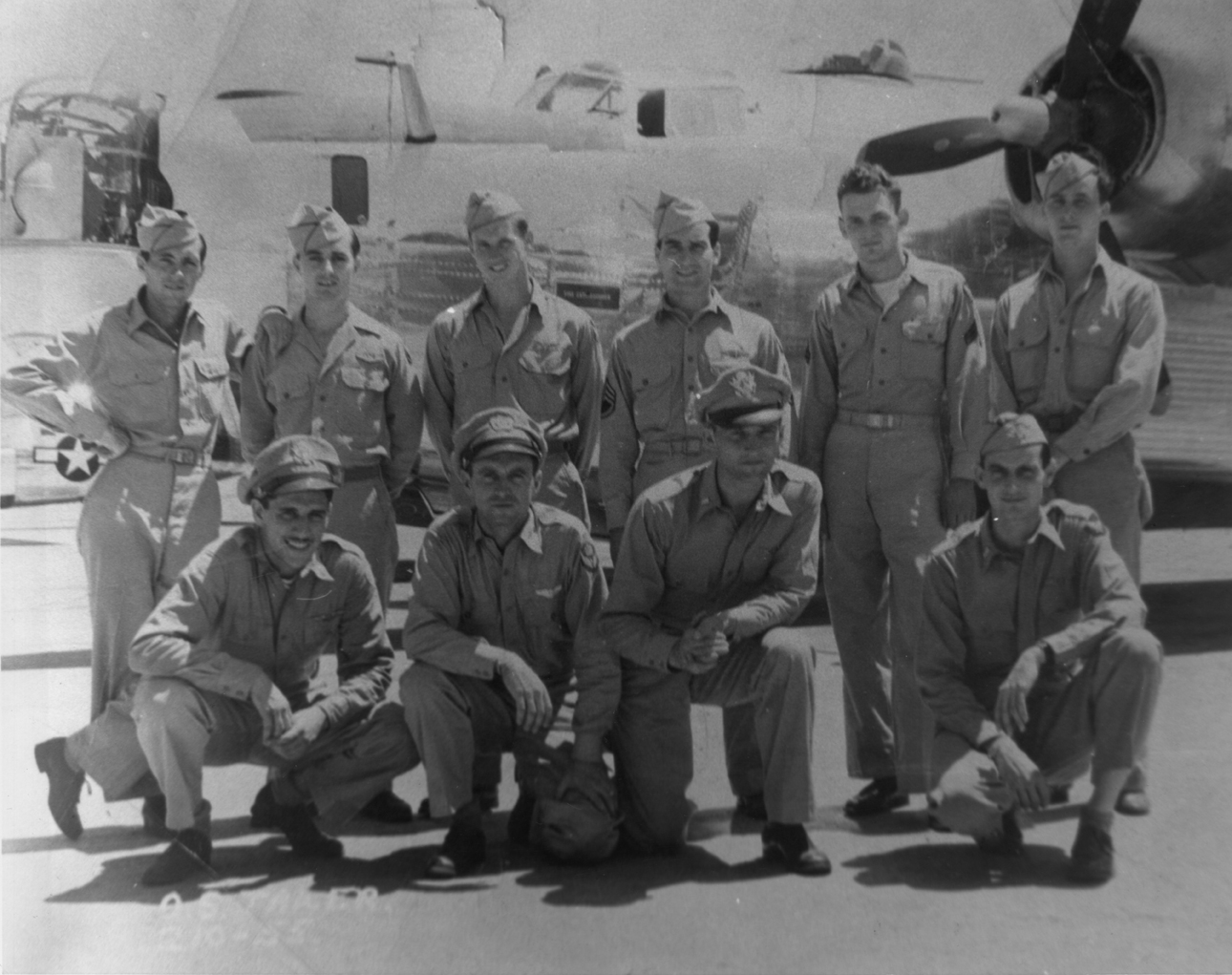 A bomber crew of the 445th Bomb Group with their B-24 Liberator. Image via Anthony P Hmura. HMmura has handwritten on the reverse: 'Left to right front row: Co-pilot- Lt Alan Goldsmith. Bombardier- Abner Musser, Lt. Pilot- Otto Tauer, Lt. Navigator- ? Forgot his name , Lt. Left to Right top row: Engineer- Morris eisenberg, T. Sgt. Asst Engineer-Anthony P Hmura, Staff Sergeant. Gunner- Jack Wikoff, S.Sgt. Radio Oper- Jack Gregerio, S. Sgt. Gunner- Richard Schultz, S. Sgt. Gunner- Trollimaier, S.Sgt. Later 