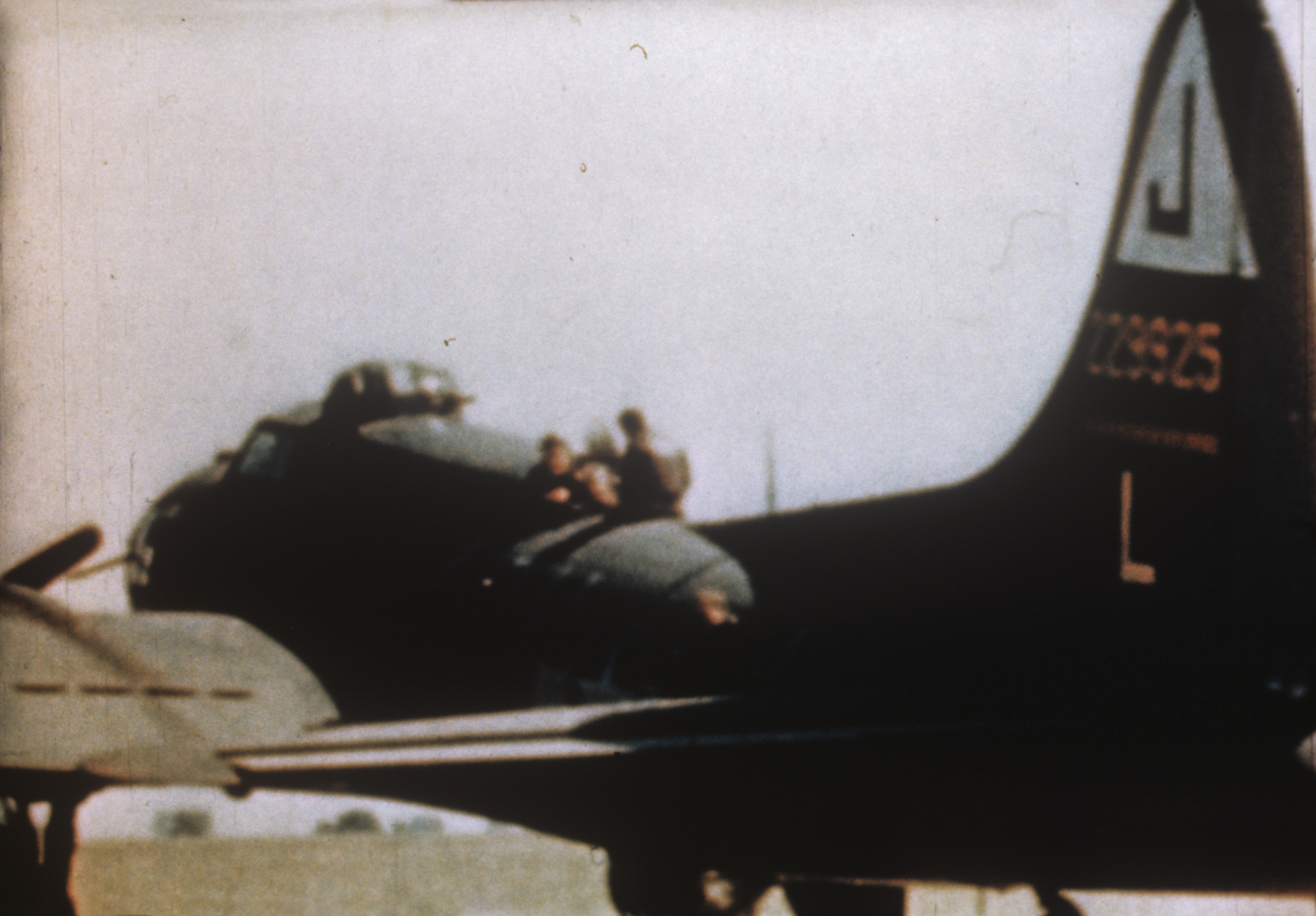 Personnel of the 351st Bomb Group sit atop a B-17 Flying Fortress (TU-L, serial number 42-29925). Film still from 'Combat America' (1943). Written on slide casing: 'TU-L, 22925 510 BS/ 351 BG.'