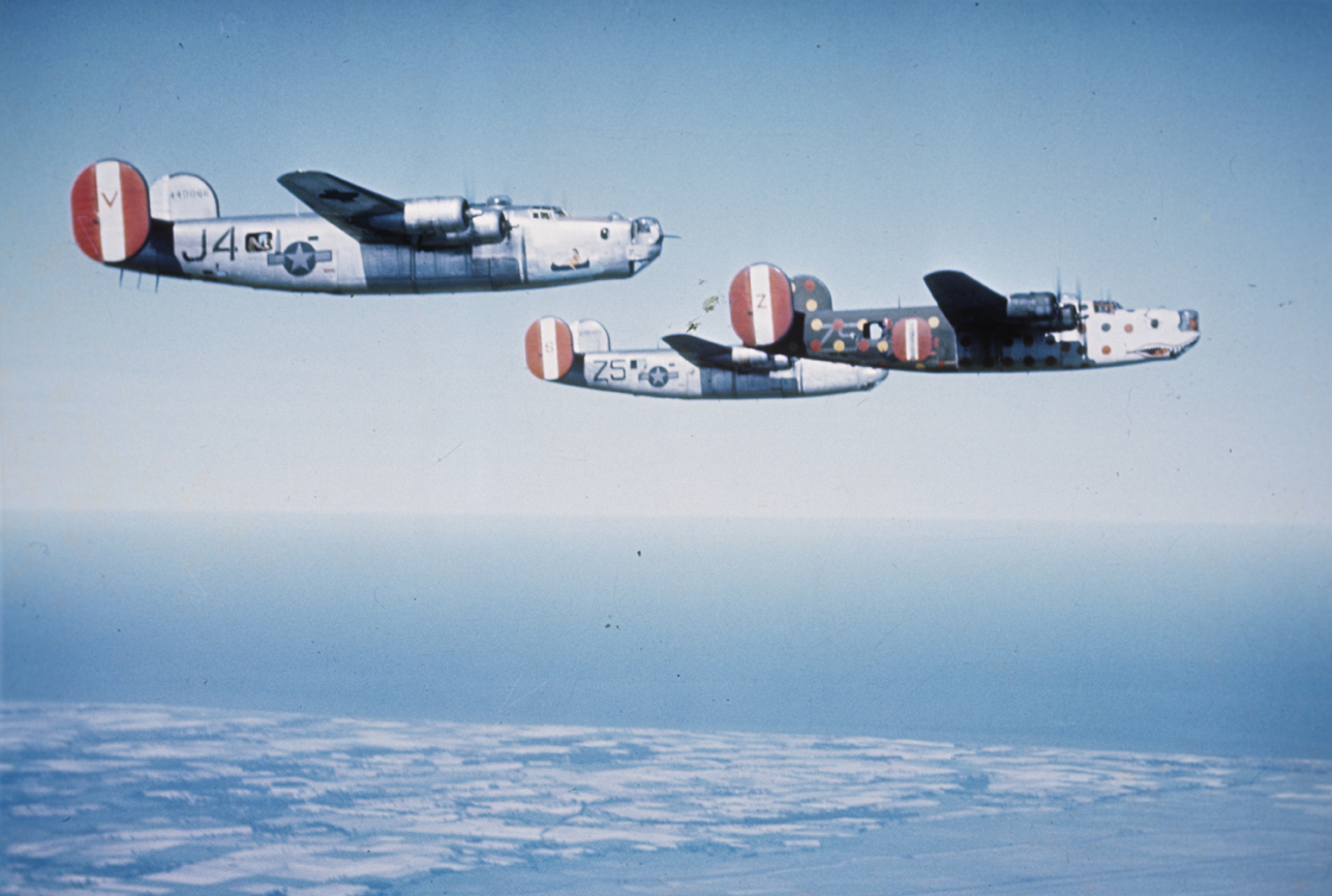 A B-24 Liberators including, (serial number 44-40066) nicknamed "S.O.L", of the 458th Bomb Group fly in formation with a flight assembly ship. Written on slide casing: 'SOL, Azon a/c.'