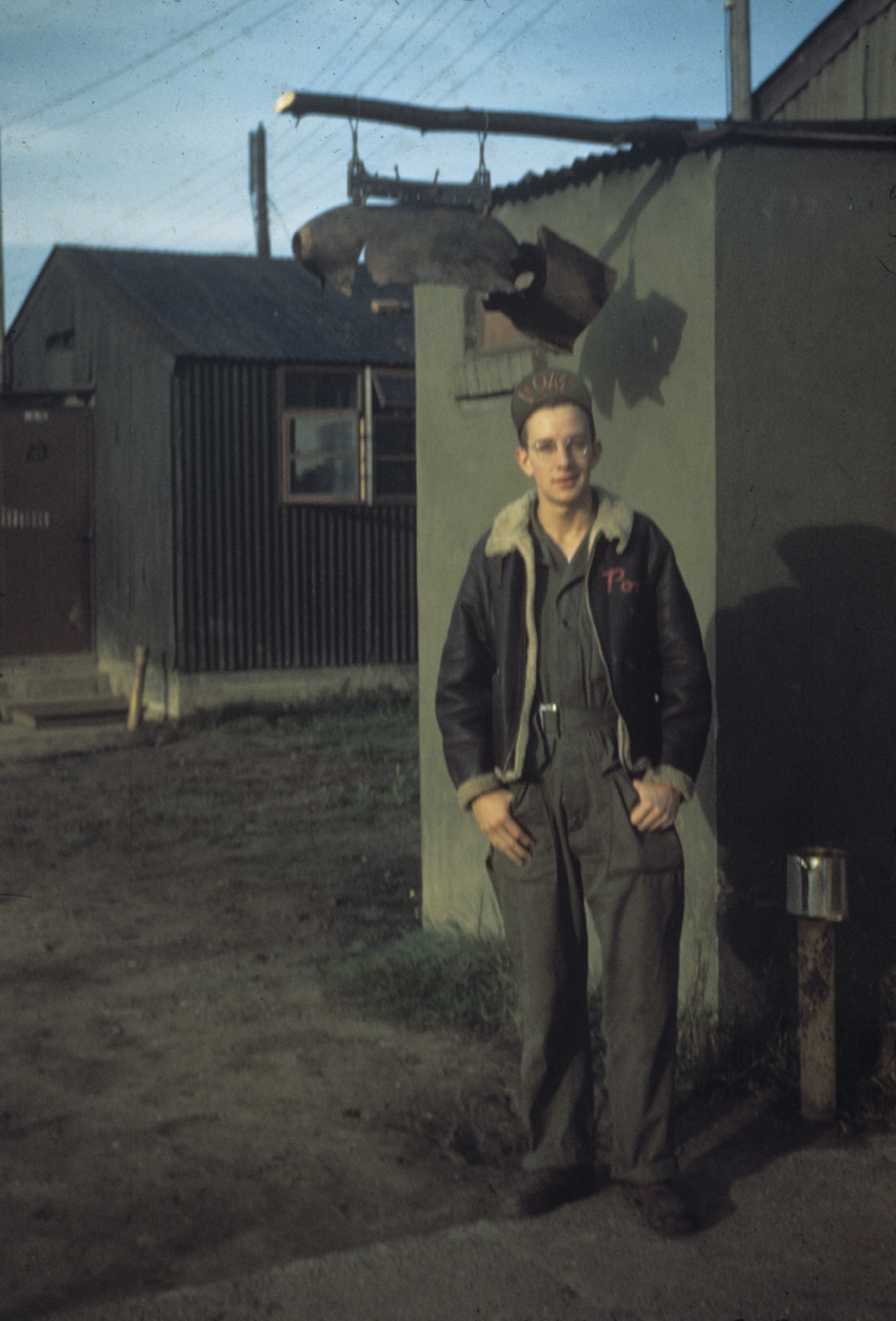 An airman ("Pom") of the 489th Bomb Group stands outside crew buildings at Halesworth. Image via W Portouw.