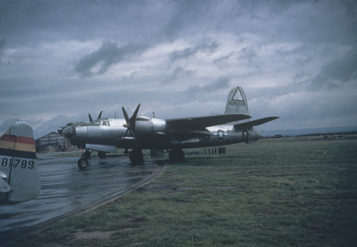 A B-26 Marauder (K9-Q, serial number 43-34568) of the 344th Bomb Group with the tail of a P-47 Thunderbolt of the 405th Fighter Group in Germany. 1945. Image via Ralph Woolner.