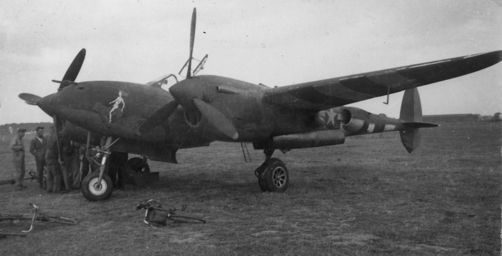 A P-38 Lightning of the 479th Fighter Group at Wendling, 5 August 1944. Handwritten on reverse: 'Visitor to Wendling [Bode]. P-38. D-Day stripes.' On reverse: John Bode [Stamp].