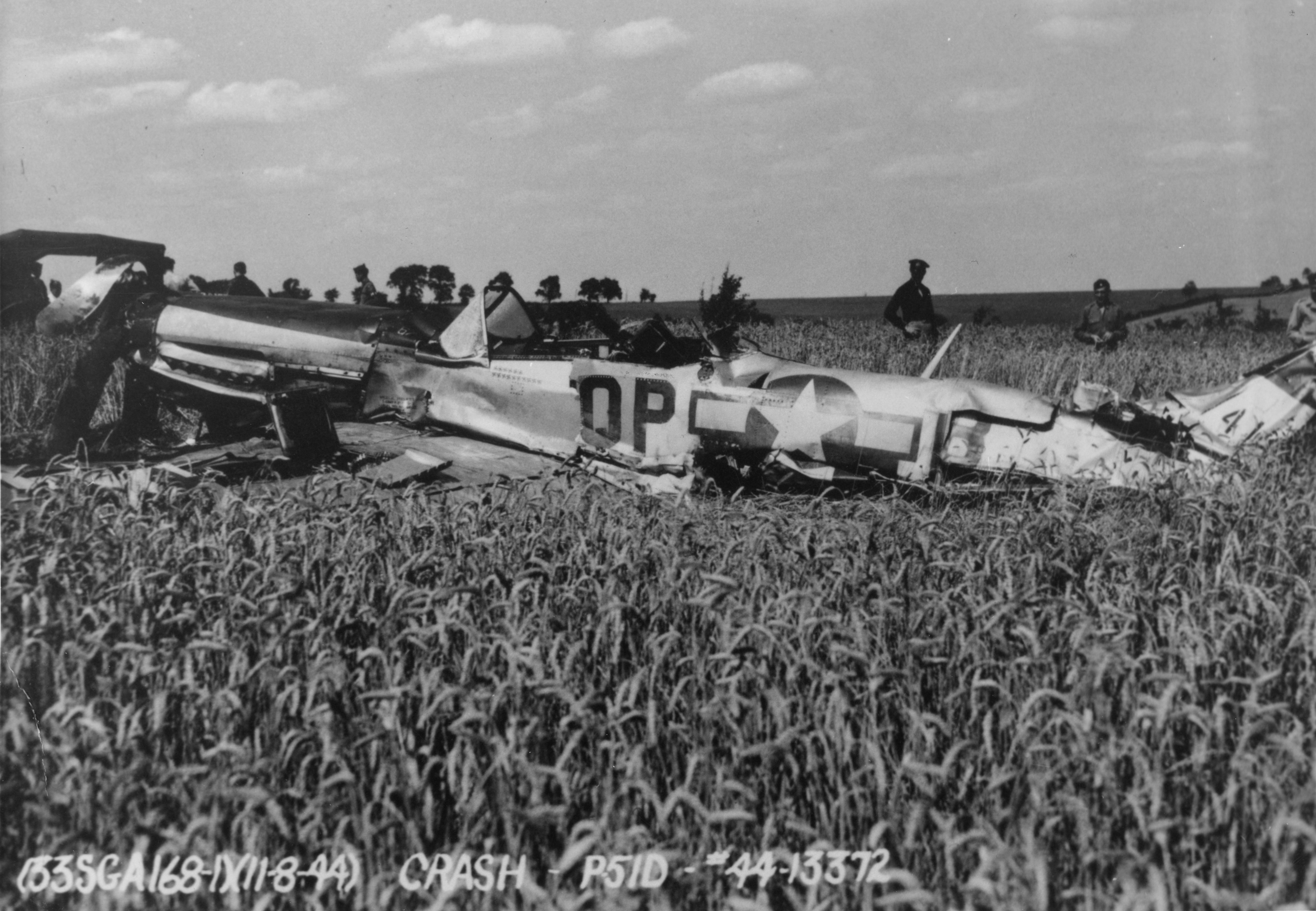 The wreck of a P-51D Mustang (QP-B, 44-13372) of the 334th Fighter Squadron, 4th Fighter Group, flown by of Lieutenant-Colonel James Clark after crash landing during a test flight by Lieutenant Willard G. Gillette. Official caption on image: "(33SGA168-1)(11-8-44) Crash - P-51D - #44-13372." Handwritten caption on reverse: 'Aug. 11, '44. L/Col James Clark's 334 P-51D, crashed on test flt by Lt. Gillette. QP-B, 44-13372. Note small kills by canopy. Source - Woody Jensen.'