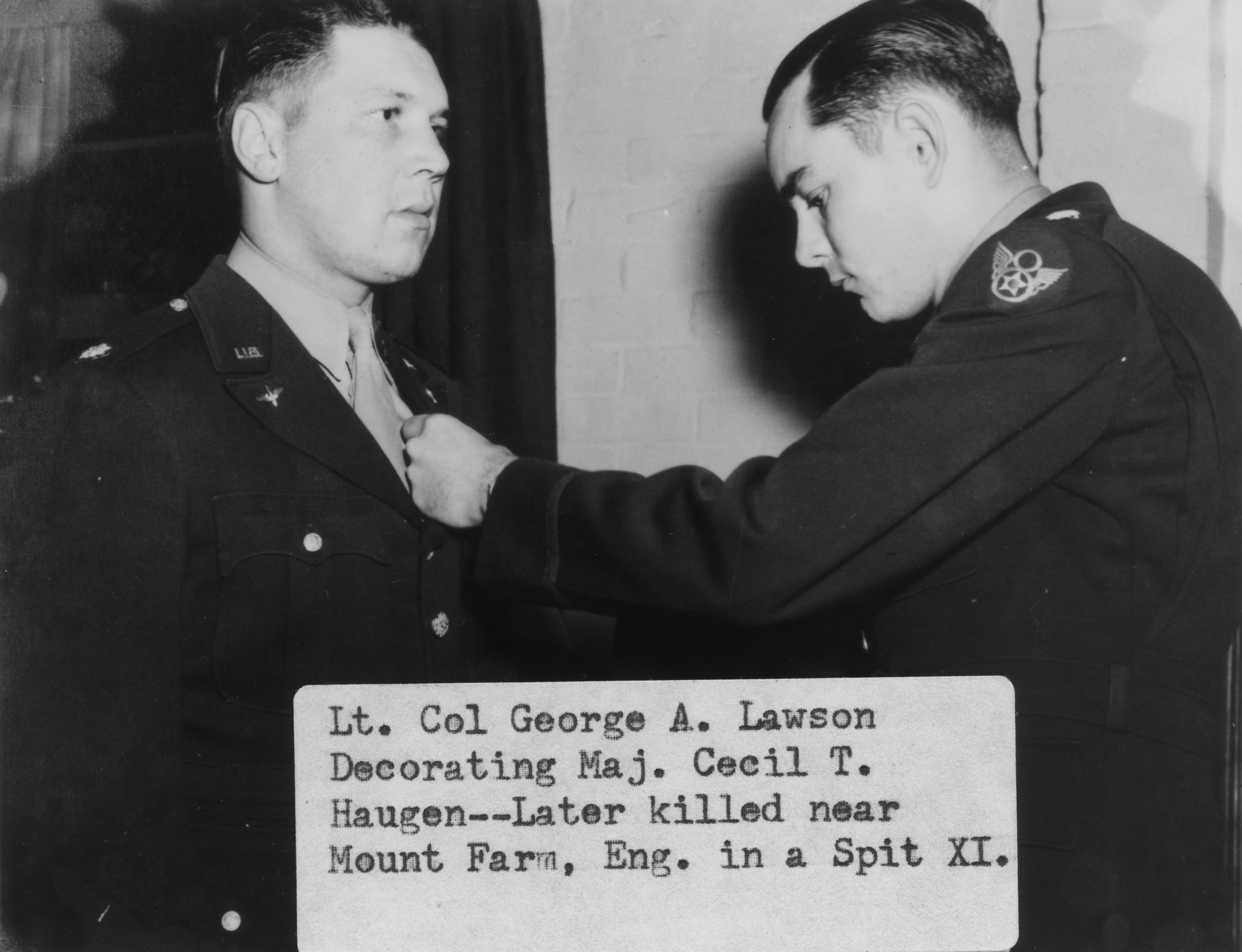 Lieutenant-Colonel George Lawson decorates Major Cecil T. Haugen, of the 7th Photographic Reconnaissance Group at Mount Farm, in March 1944. caption on image: "Lt. Col. George Lawson Decorating Maj. Cecil T. Haugen ... Later killed near Mount Farm, Eng. in a Spit XI."