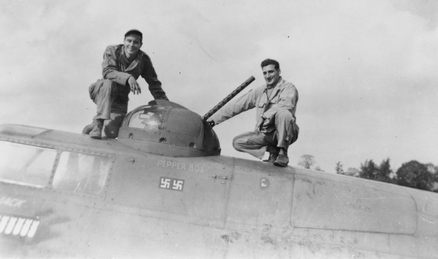 Two airmen of the 303rd Bomb Group with the top turret of a B-17 Flying Fortress. Handwritten caption on reverse: '303. 91.' Printed caption removed from reverse.