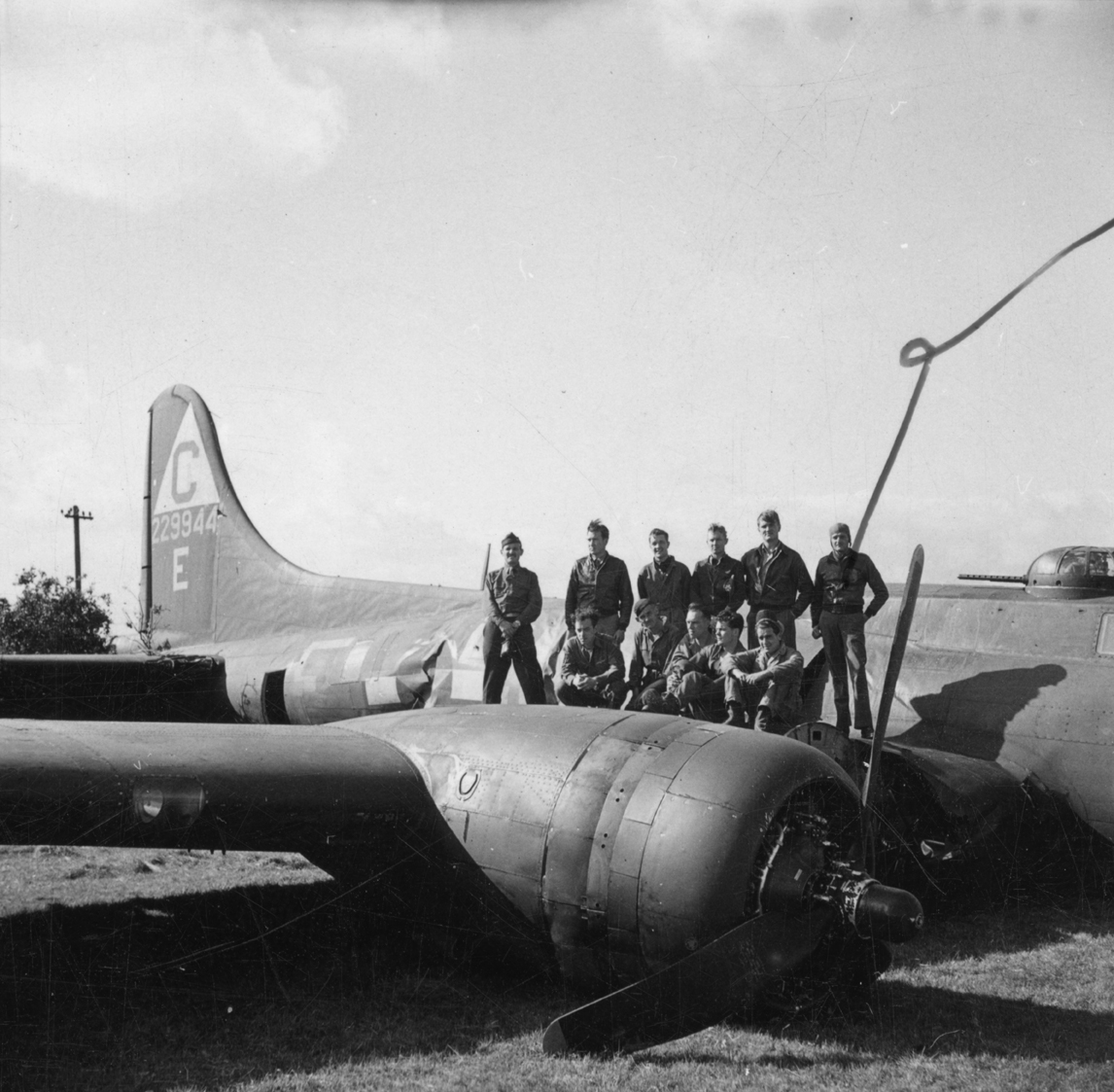 A bomber crew of the 303rd Bomb Group stand on the wing of their B-17 Flying Fortress (serial number 42-29944) that has crash landed. Passed as censored 10 Sep 1943. Handwritten caption on reverse: '6/9/43. Crash - south coast. #3.' On reverse: US Army Press Censor ETO [Stamp].