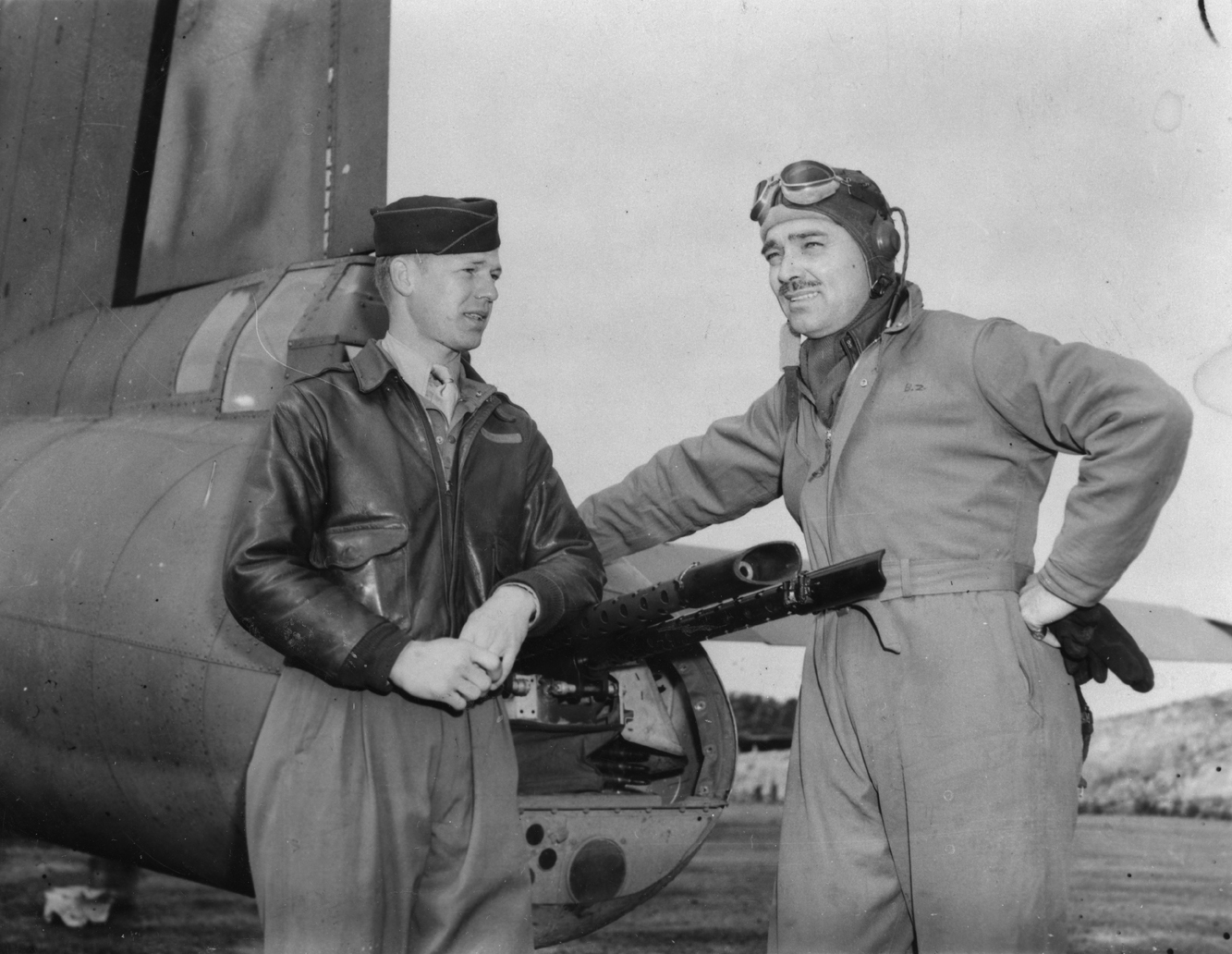 Hollywood Actor Clark Gable talks to Sergeant Phil Hulse of the 91st Bomb Group by the tail guns of a B-17 Flying Fortress. Passed for publication 6 Jun 1943. Printed caption on reverse: 'Clark Gable Serves In England: Clark Gable has slipped into this country as Capt. Gable and is serving with the U.S. Army Air Force somewhere in England, as a Gunnery Instructor. He hopes that his movements will not be accompanied by the publicity that he had a while ago, because he wants to get down to the job as others