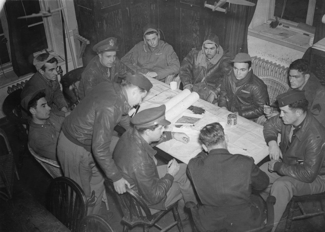 A bomber crew of the 91st Bomb Group at interrogation after a mission. Passed for publication 24 Mar 1943. Printed caption on reverse: 'Fortresses' Day Raid on Wilhelmshaven - The German Naval Base at Wilhelmshaven was successfully attacked in daylight March 22 by American Flying Fortresses and Liberators. This was the third heavy raid for U.S. bombers on Wilhelmshaven. Despite strong fighter opposition, the bombers battled their way to the target and dropped their loads of explosives. Three bombers were 