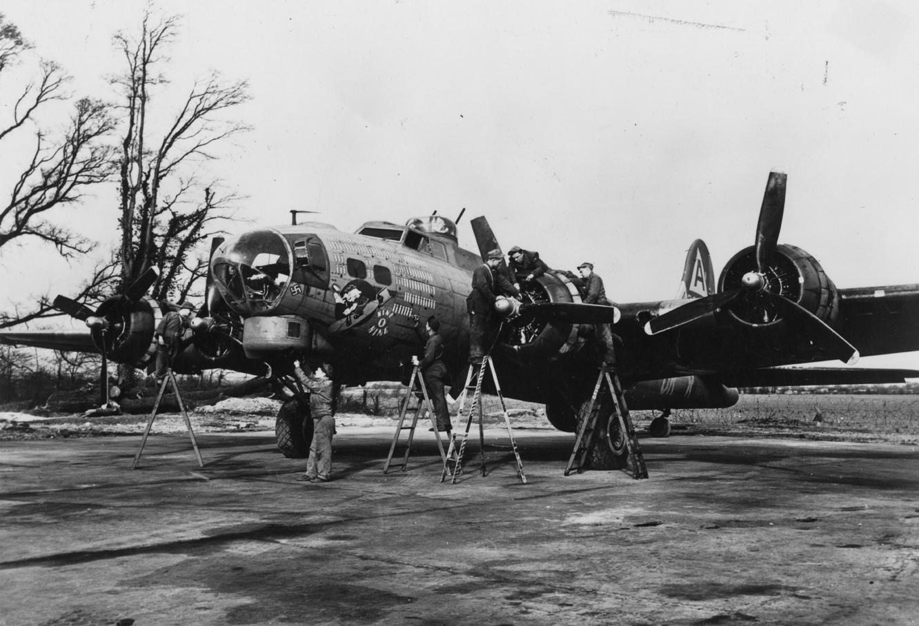 Ground personnel of the 91st Bomb Group work on the engines of a B-17 Flying Fortress nicknamed "Nine O Nine".