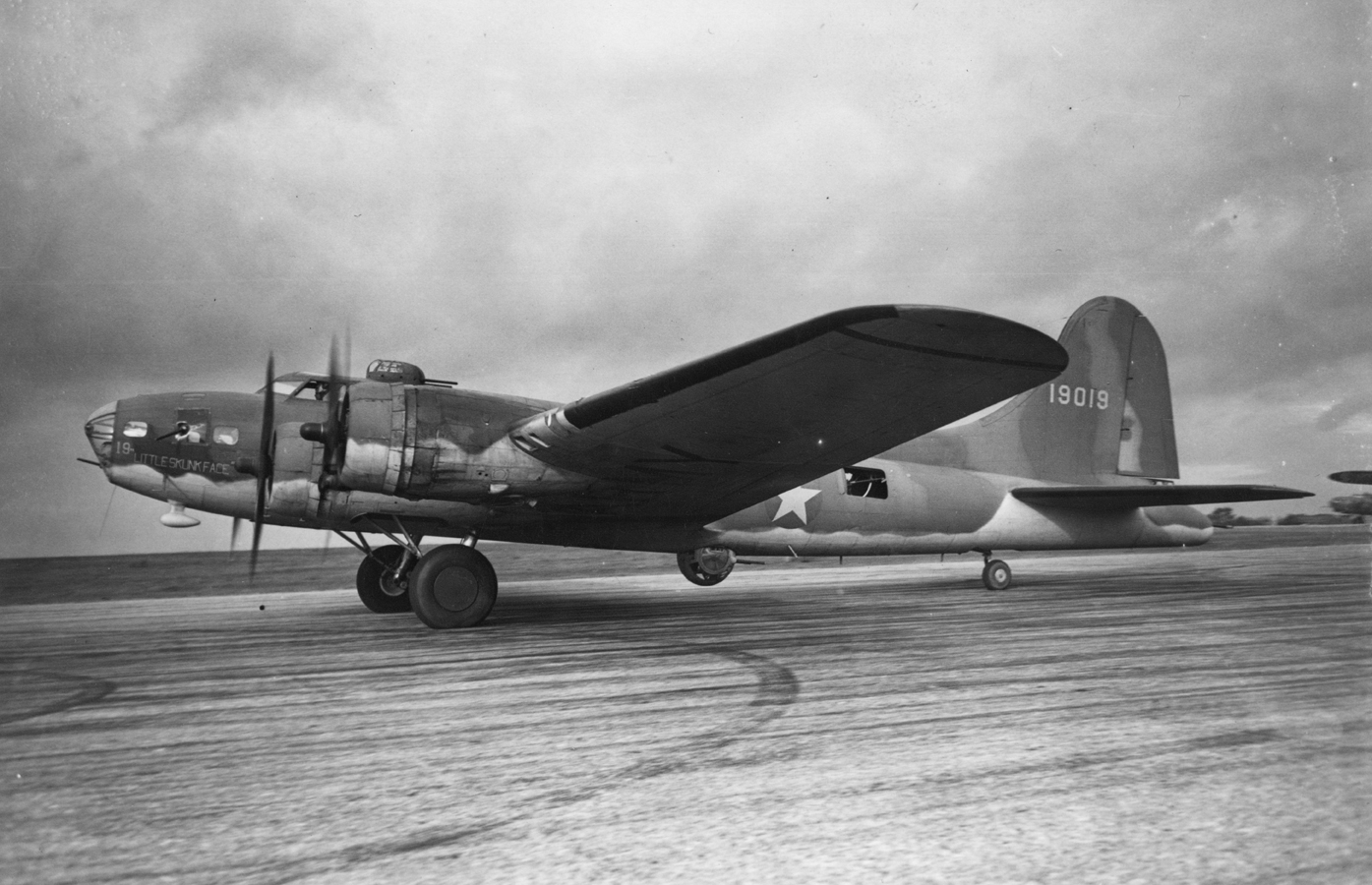 A B-17 Flying Fortress (serial number 41-9019) nicknamed "Little Skunk Face" of the 92nd Bomb Group prepares for take off. Printed caption on reverse: 'New "Fortress" Makes History In The Air. Oct. 1942. The most striking development of the war in the air is undoubtedly the sensational success of the American "Boeing" Flying Fortresses in the daylight bombing of enemy-occupied territory. In the most recent operation 105 German craft were destroyed, probably destroyed or damaged, for the loss of four bombe