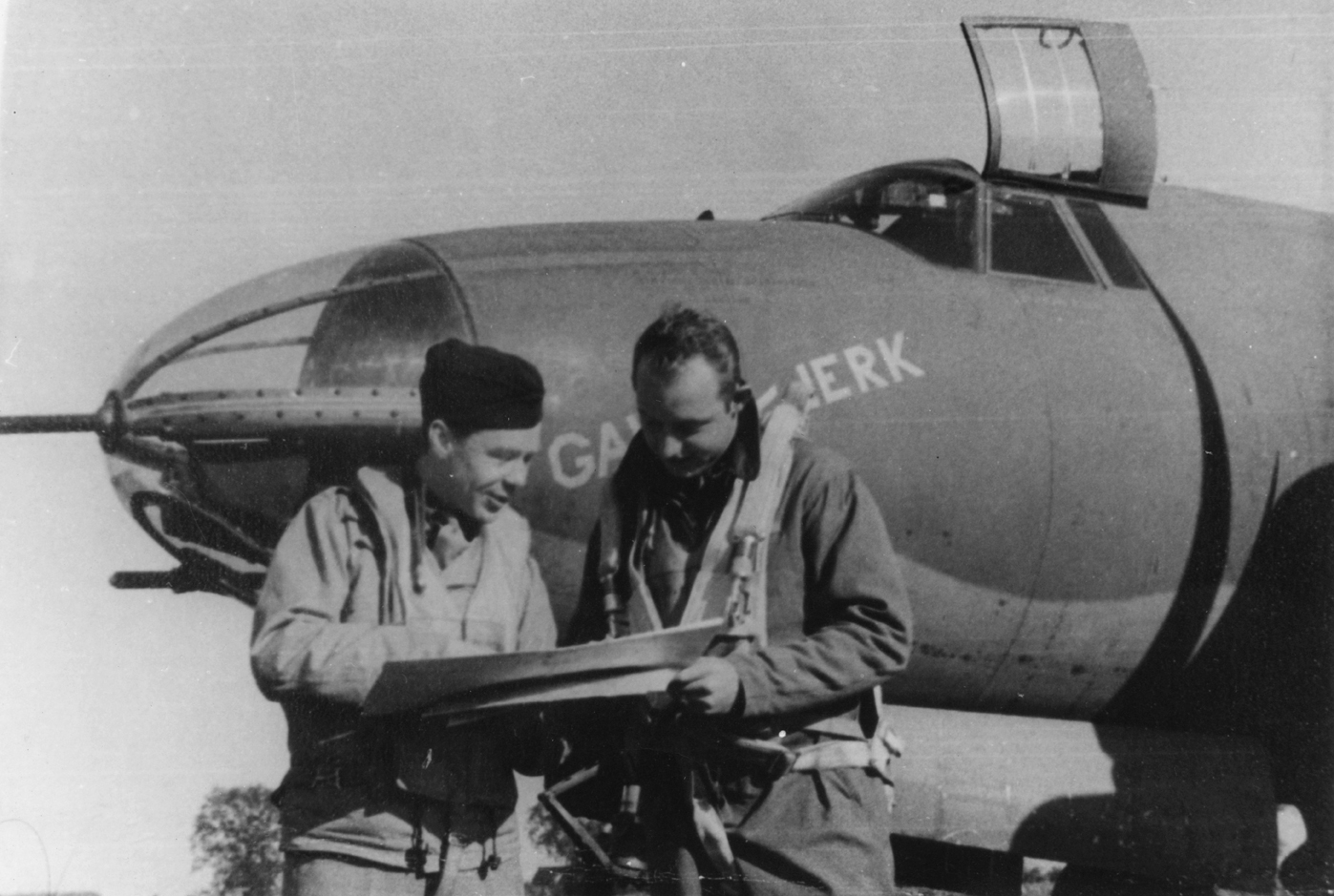 Airmen of the 322nd Bomb Group read documents in front of a B-26 Marauder (ER-D, serial number 41-17929) nicknamed "GAWJA-JERK".