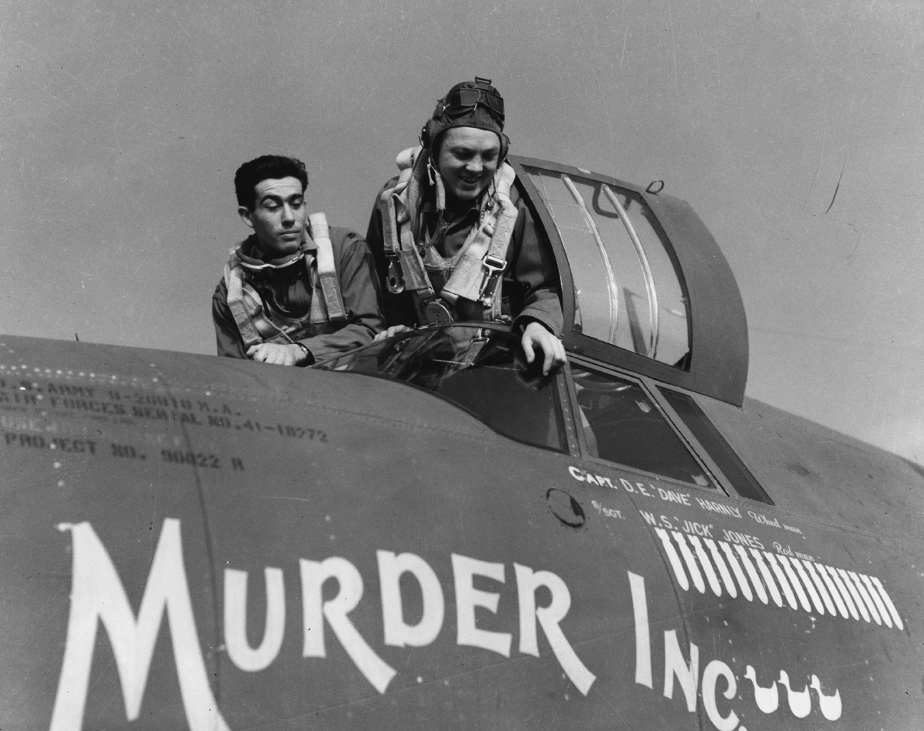 Airmen of the 322nd Bomb Group with a B-26 Marauder nicknamed "Murder Inc.". Handwritten caption on reverse: 'Mr. Freeman: Could this be the aircraft mentioned on page 101 of your "Mighty Eighth"? Or was there another "Murder Inc.", a B-17?' Printed caption on reverse: 'C-60523 A.C. - Martin B-26, nicknamed "Murder Inc.", of the 322nd Bomb Group, Andrews Field, Essex, England, 15 Oct. 1943.' On reverse: U.S. Air Force Photo and Rene J. Francillon [Stamps].