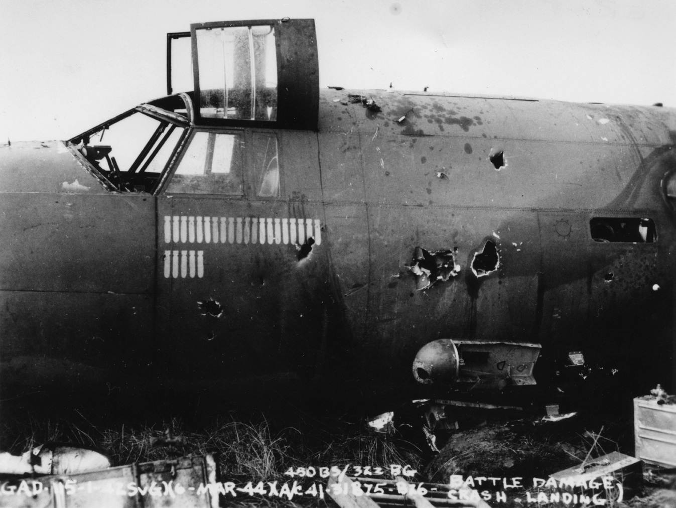 The wreck of a B-26 Marauder (ER-P, serial number 41-31875) of the 450th Bomb Squadron, 322nd Bomb Group, 6 March 1944. Official caption on image: "(GAD-115-1-475vG)(6-Mar-44)(A/C 41-31875 - B26 - 450BS/322BG - Battle Damage/Crash Landing)." Handwritten caption on reverse: 'Howard Posson. ER-P. Smile Again Operator.'