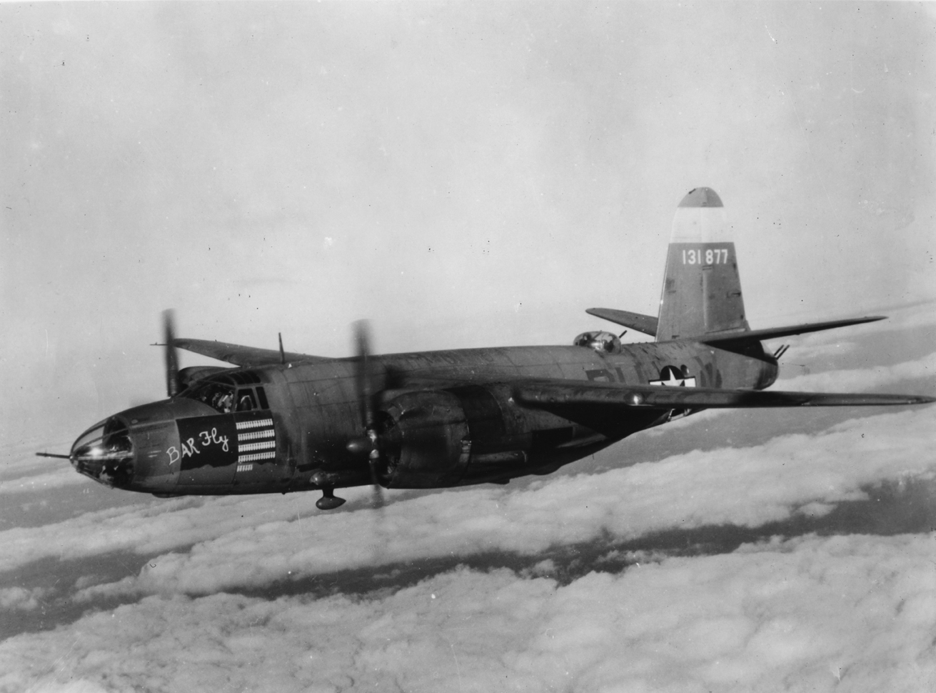 A B-26 Marauder (RU-V, serial number 41-31877) nicknamed "Bar Fly" of the 554th Bomb Squadron, 386th Bomb Group in flight. Handwritten caption on reverse: 'B-26 (41-31877), RU-V, "Bar Fly" of 554B.S., 386 B.G., Ninth AF.' Printed caption on reverse: '62812 A.C. - 9th Air Force Martin B-26 Marauder "Bar Fly", after 175 missions, crashed on take-off to end one of the best records in the Air Force. This shot was taken on its 67th mission, France. U.S. Air Force Photo.' On reverse: U.S. Air Force Detachment-5