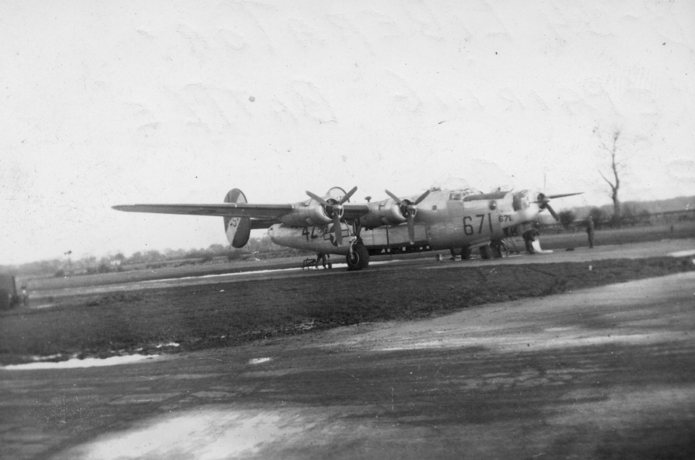 A B-24 Liberator (4Z-S) of the 792nd Bomb Squadron, 467th Bomb Group undergoing maintenance and having its battle damage repaired. Handwritten caption on reverse: 'B-24 Liberator - Repairing battle damage.' Second handwritten on reverse: 'C.E. Jackson, 467BG.'