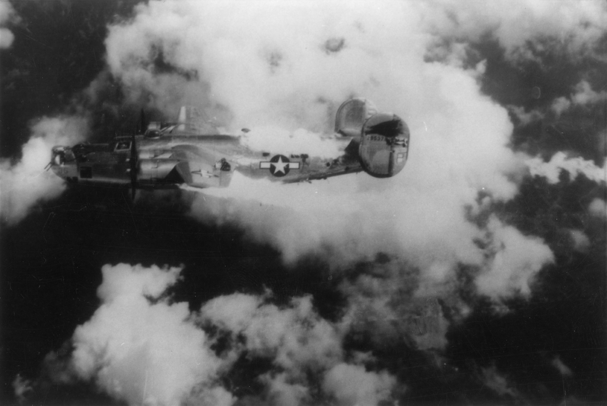 A B-24 Liberator (serial number 42-95379) nicknamed "Extra Joker" of the 451st Bomb Group, 15th Air Force on fire over Austria following an attack by German fighters. Image taken by Leo S Stoutsenberger, Photographic Officer, 451st Bomb Group. Handwritten caption on reverse: '3 of 3 Vienna- Aug 1944, 451st- 725th? Sq Photo by S Stoutsenberger. name of ship: "Extra Joker".'