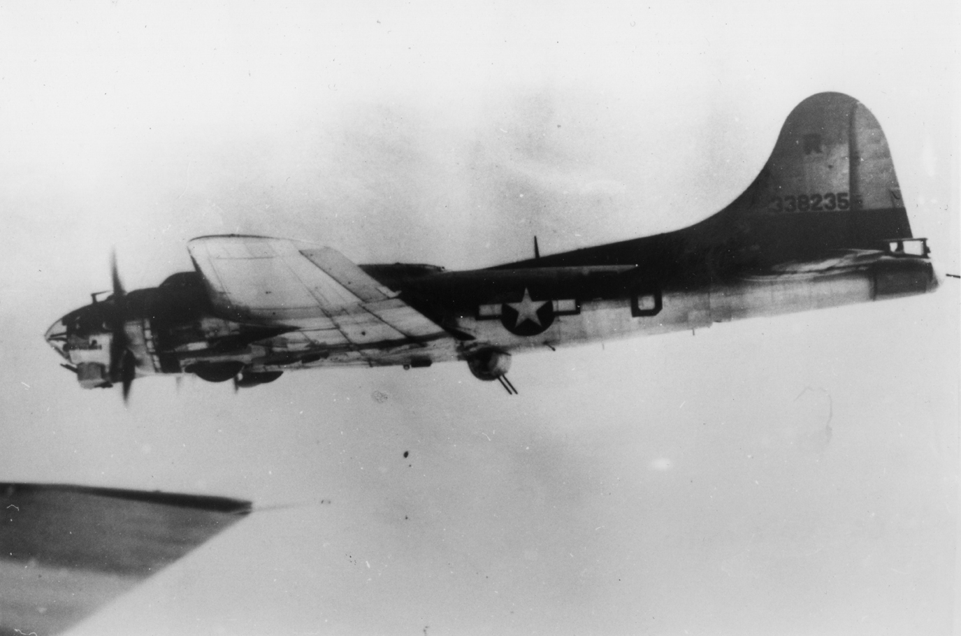 A B-17 Flying Fortress (serial number 43-38235) nicknamed "Skipper" of the 493rd Bomb Group in flight. Handwritten caption on reverse: 'R, 338235, 493 BG, Ed O Neill.'