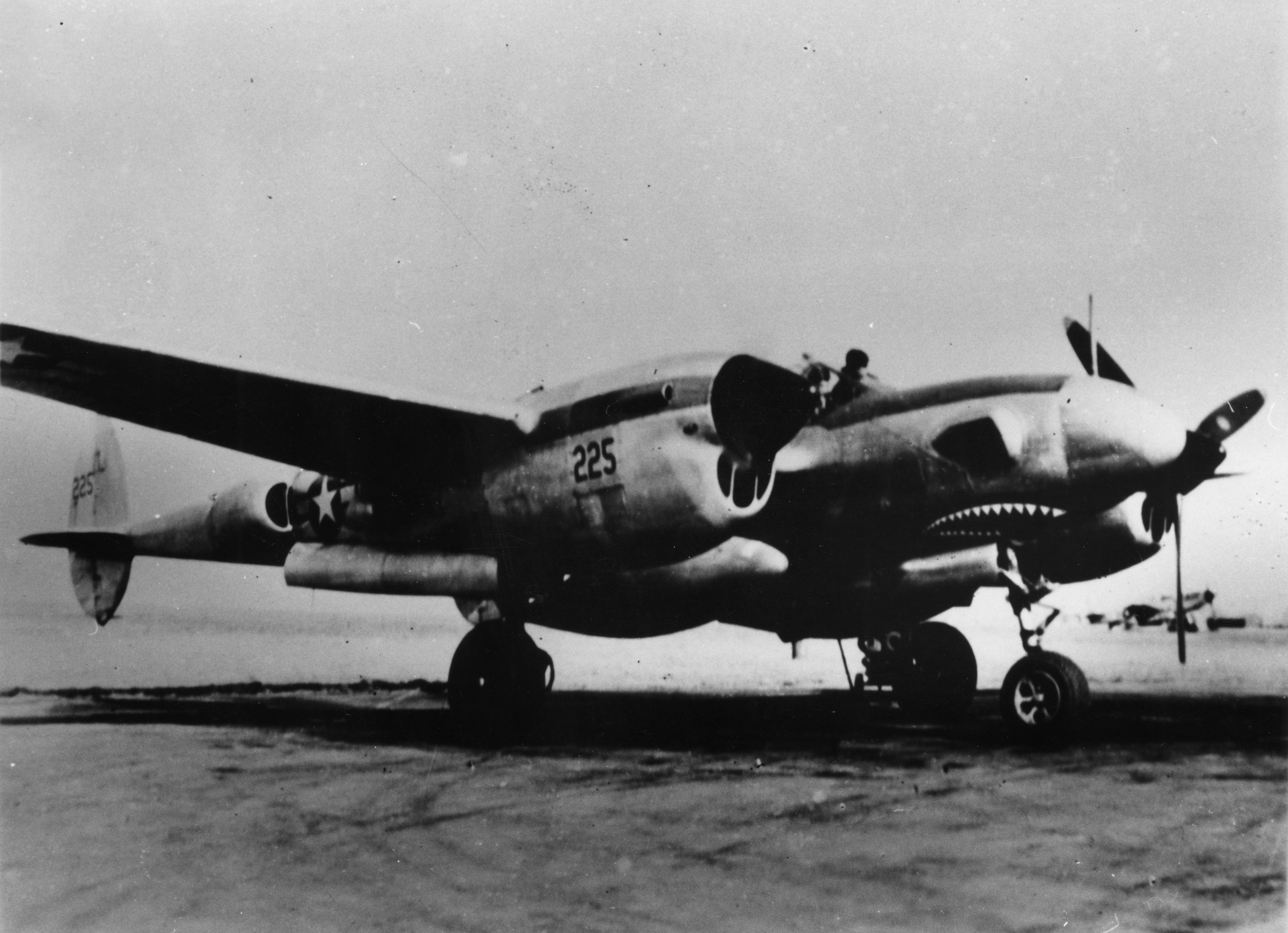 A shark mouth F-5 Lightning of the 7th Photographic Reconnaissance Group . Handwritten caption on reverse: ''225' 7PG, Dark bue spinners/ red strip.'