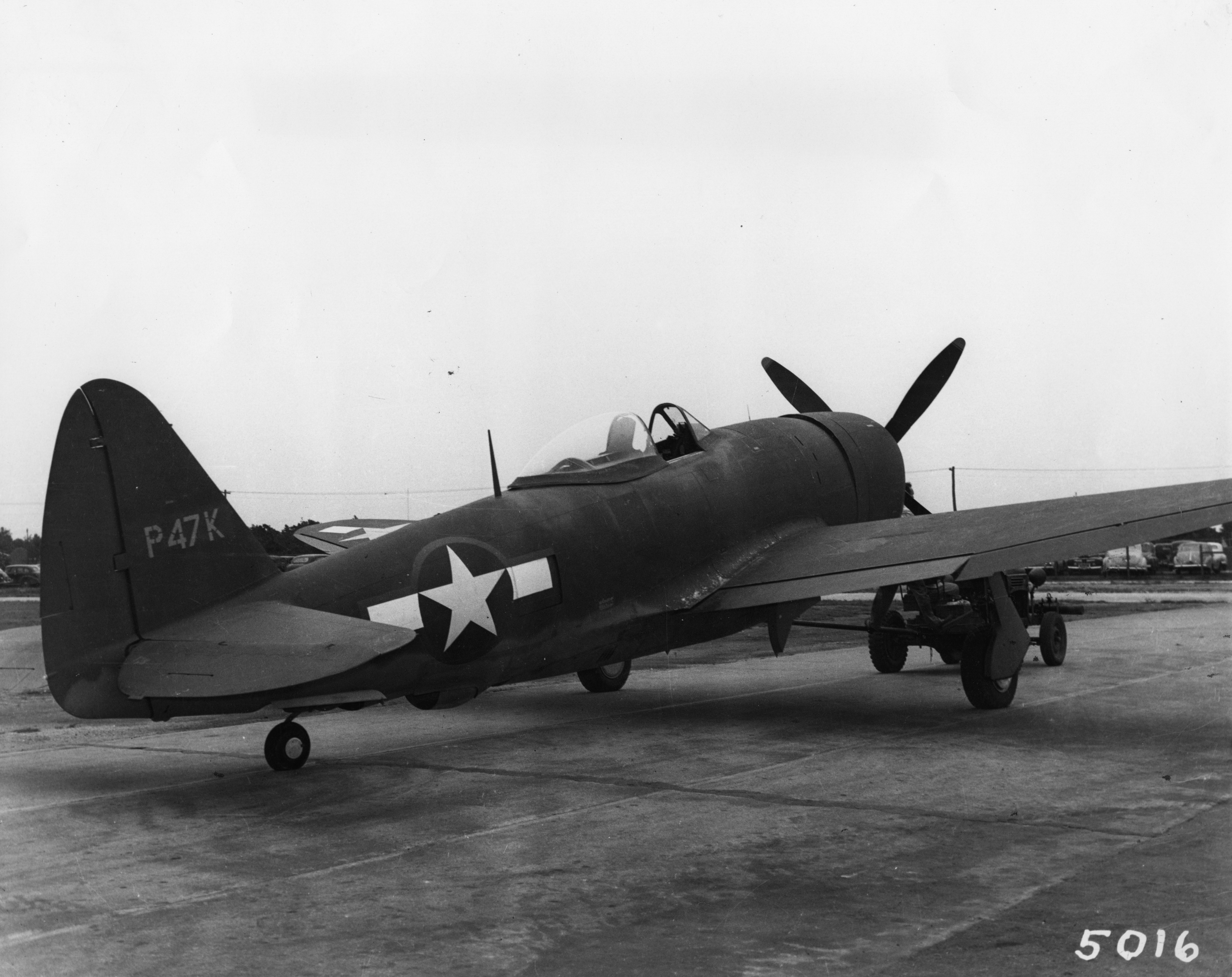 An XP-47K, experimental variant of the P-47 Thunderbolt. Image stamped on reverse: 'Republic Aviation Division.' Printed caption on reverse: 'CP-47K- The Republic XP-47K was built as the first prototype airplane to test the use of the bubble canopy. It became the plane which proved the practicability of bubble canopies for fighter planes. It was completed July 3 1943.'