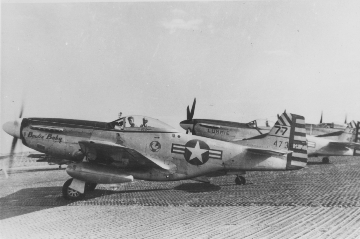 Two P-51 Mustangs, ('77', serial number 44-73927) nicknamed "Bowlin' Baby" in front and ('72') nicknamed "Lummie" behind. Handwritten caption on reverse: '41st F. Sqdn.' Second handwritten on reverse: '314th F.B.G.' [Note: Conflicting handwritten captions.]